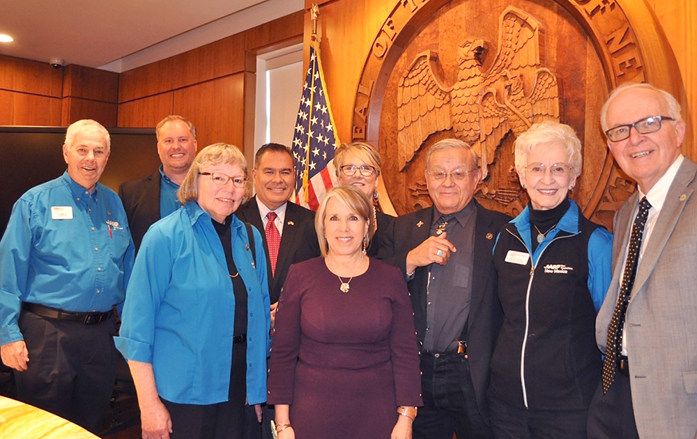 Left to right: Three AARP New Mexico volunteers, Sen. Michael Padilla, Governor Michelle Lujan Grisham, Rep. Gail Armstrong, Rep. Tomas Salazar, AARP New Mexico President Jackie Cooper, and Sen. Bill Tallman. The four legislators sponsored HB 44, the Work and Save Act.