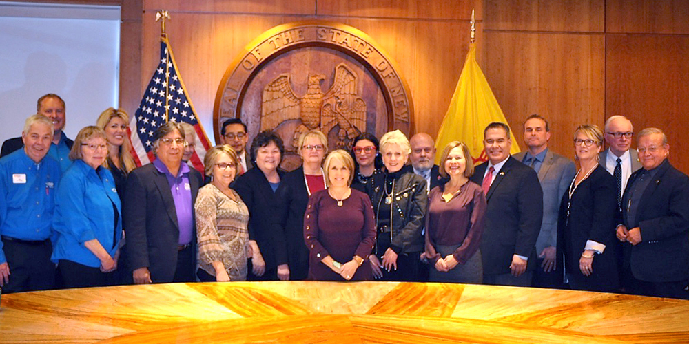 Governor Michelle Lujan Grisham surrounded by sponsors and AARP New Mexico volunteers who worked on House Bill 44, the Work and Save Act.